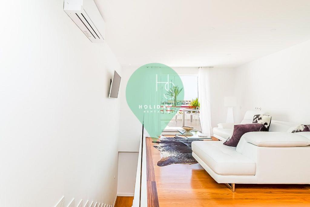 Vista dos Seus Sonhos T2 HsR Vilamarina في كوارتيرا: غرفة معيشة مع أريكة بيضاء وطاولة