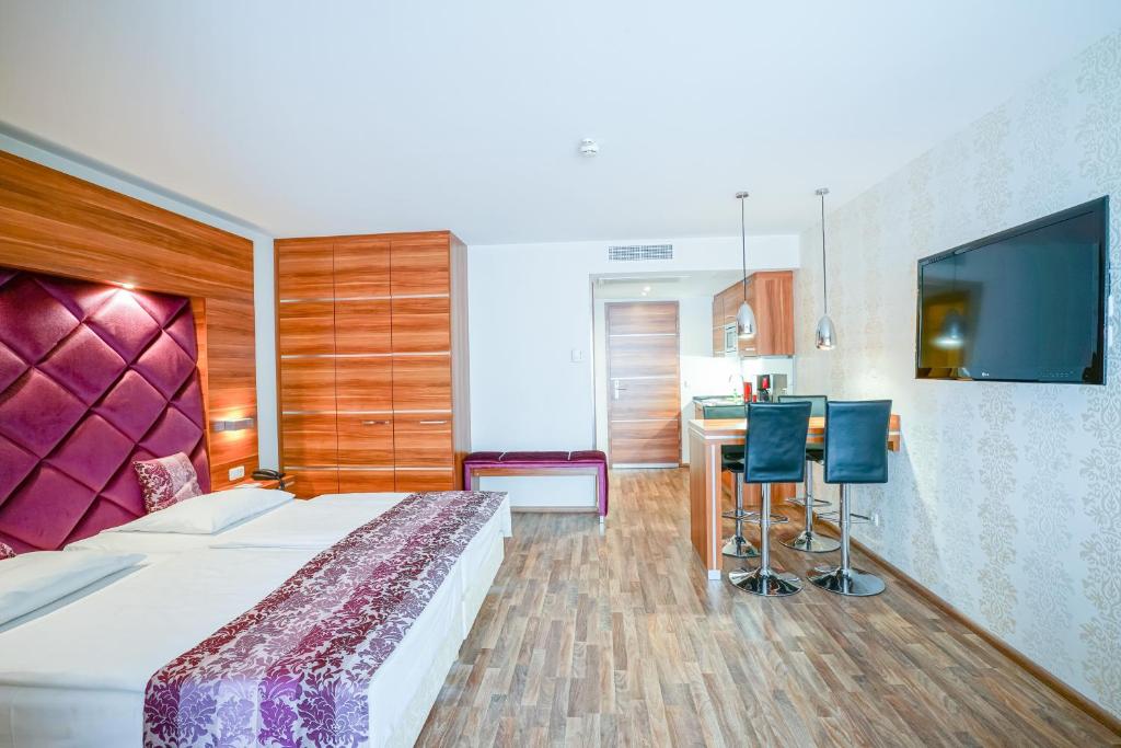 a bedroom with a bed and a desk and a television at Arkona Strandresidenzen in Binz