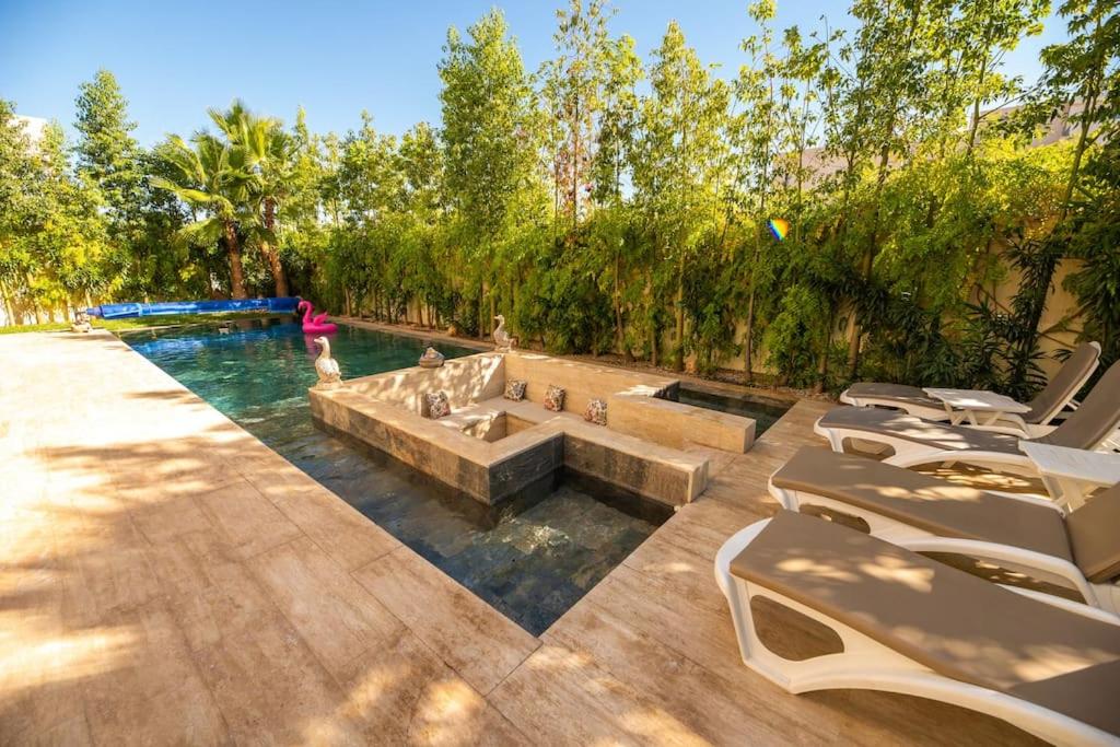 - une piscine avec une fontaine au milieu dans l'établissement Superbe Villa avec Vue sur l'Atlas au Cœur de Marrakech, à Marrakech