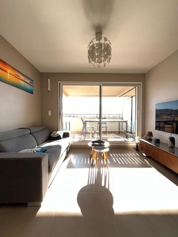 uma sala de estar com um sofá e uma grande janela em vue mer-garage-500m port et plage em Sanary-sur-Mer