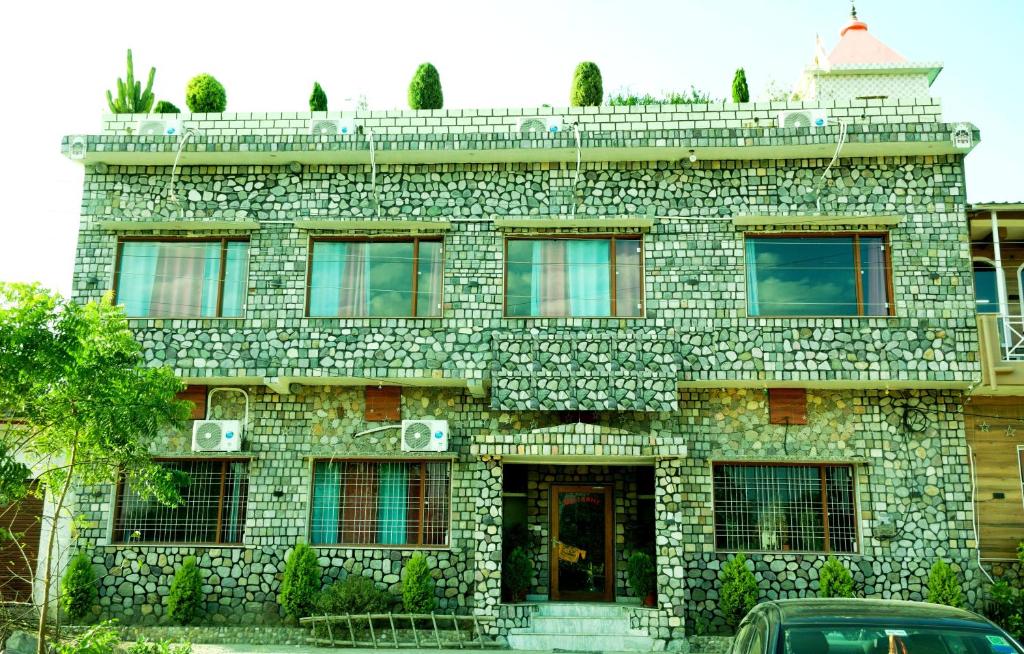 a stone building with a car parked in front of it at The Corbett Stay in Rāmnagar