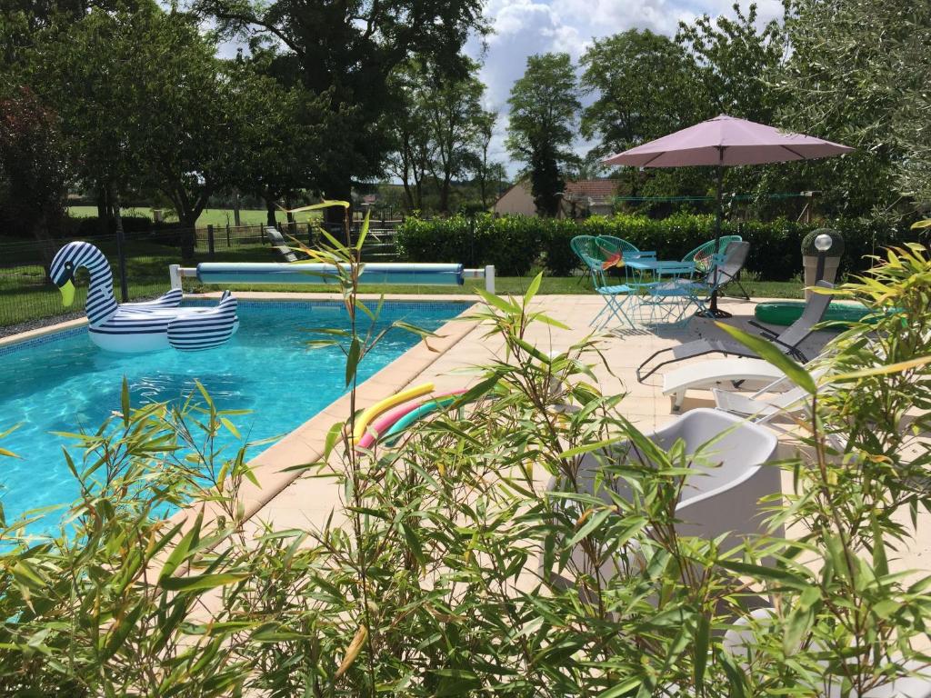 a swimming pool with chairs and an umbrella at Gîte Cures, 3 pièces, 5 personnes - FR-1-410-321 in Cures