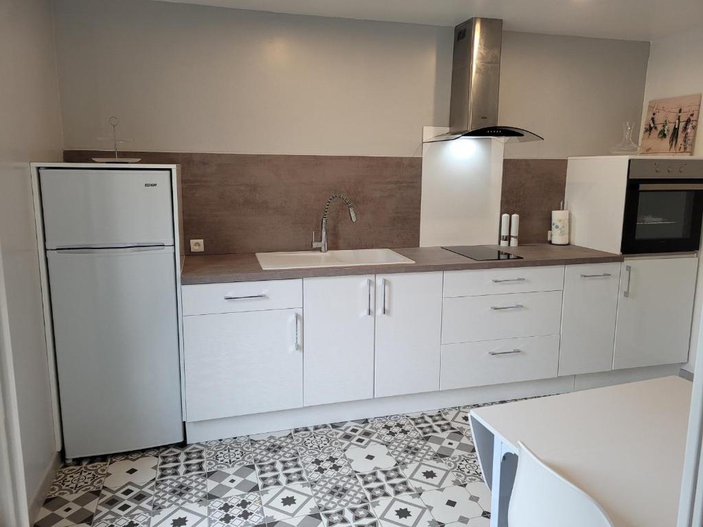 uma cozinha com um frigorífico branco e um lavatório em Gîte Louplande, 1 pièce, 4 personnes - FR-1-410-364 em Louplande