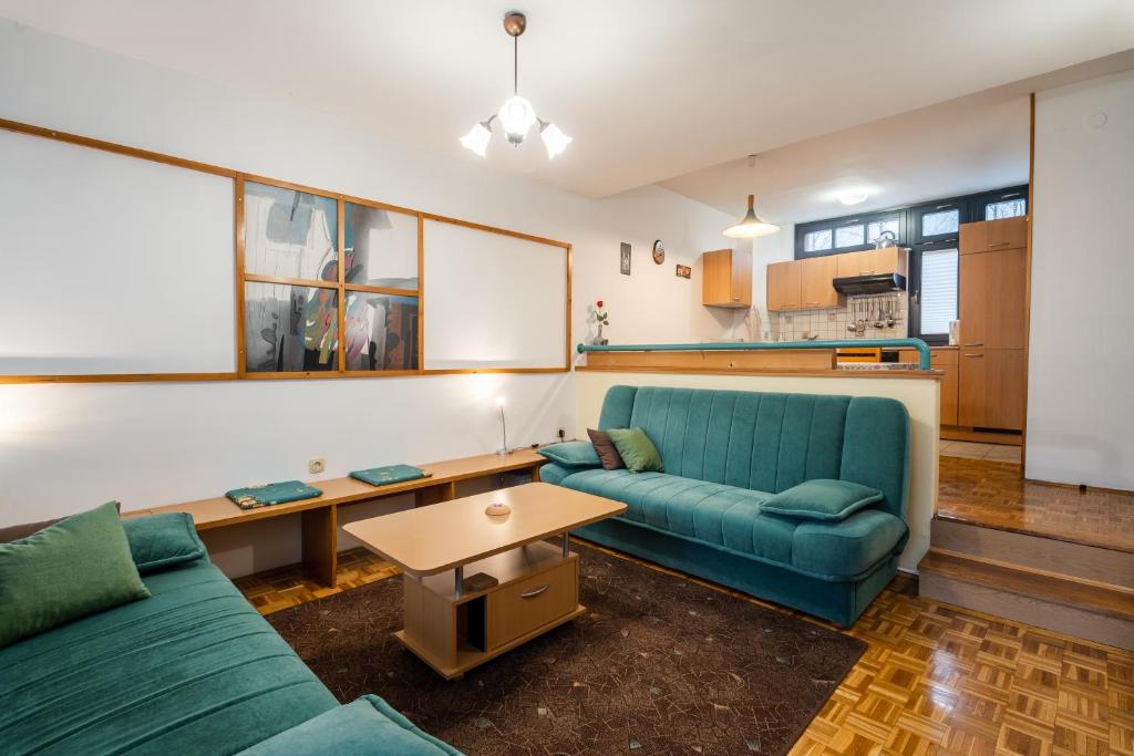 a living room with a blue couch and a table at Apartment Maj, Kranjska Gora in Kranjska Gora