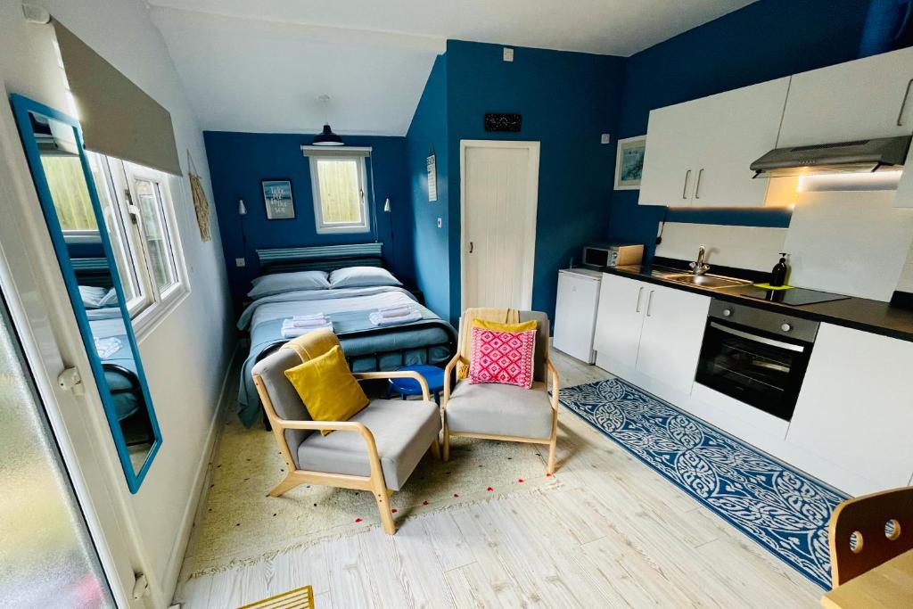 Habitación pequeña con 2 camas y cocina en Fistral Studio, en Newquay
