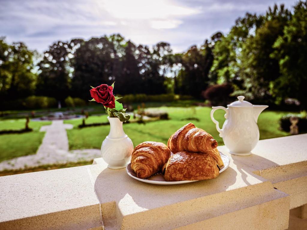 talerz wypieków i wazon z różą w obiekcie Grand Château Renaissance avec Parc, Piscine et Activités, Rénové en 2023 - FR-1-410-389 w mieście Vallon-sur-Gée