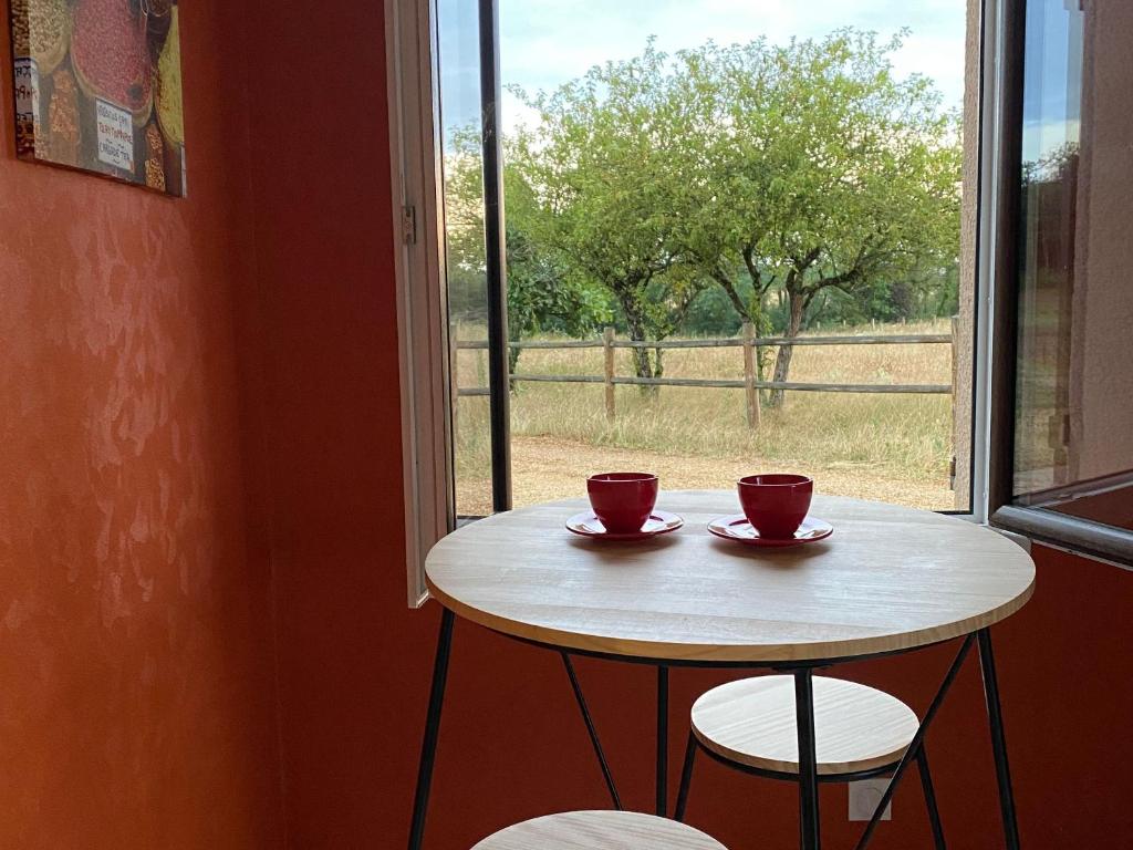 einem Tisch mit zwei Tassen vor einem Fenster in der Unterkunft Gîte Le Lude, 3 pièces, 4 personnes - FR-1-410-413 in Le Lude