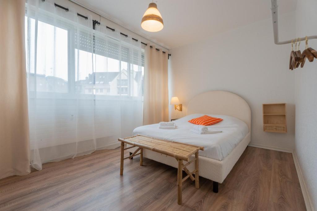 a white bedroom with a bed and a table at MUL HOUSE in Mulhouse