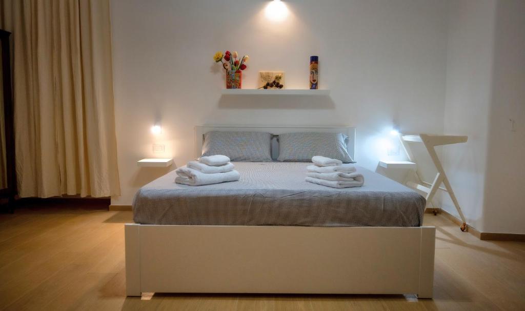 1 dormitorio con 1 cama con toallas en Giachery House Palermo, 4 min. dalla stazione Giachery en Palermo