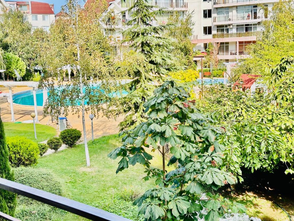 a view of a park with a tree and a pool at Charming 2-bed flat with pool view in Sunny Beach, Bulgaria in Sunny Beach