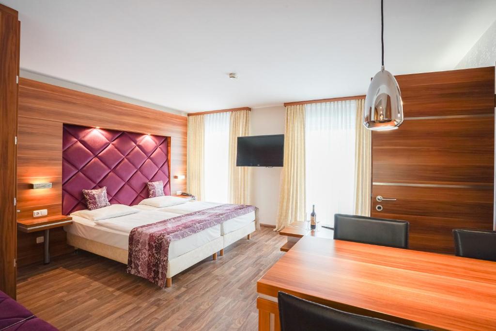 a bedroom with a bed with a purple headboard at Arkona Strandresidenzen in Binz