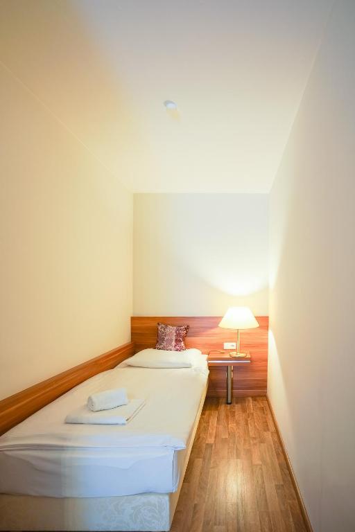 a small room with a bed and a lamp at Arkona Strandresidenzen in Binz