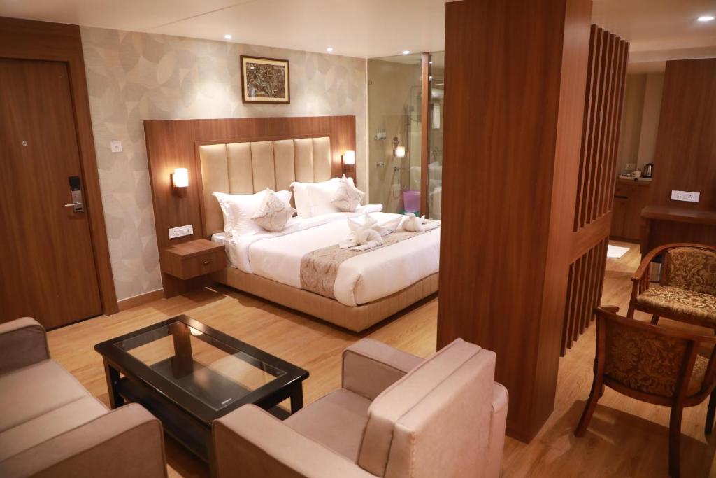a bedroom with a bed and a living room at HOTEL RAMTA CONTINENTAL in Patna