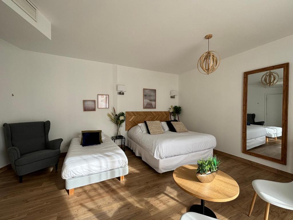 a bedroom with two beds and a chair and a mirror at LA TOUR AUX CRABES près de la plage in Dieppe
