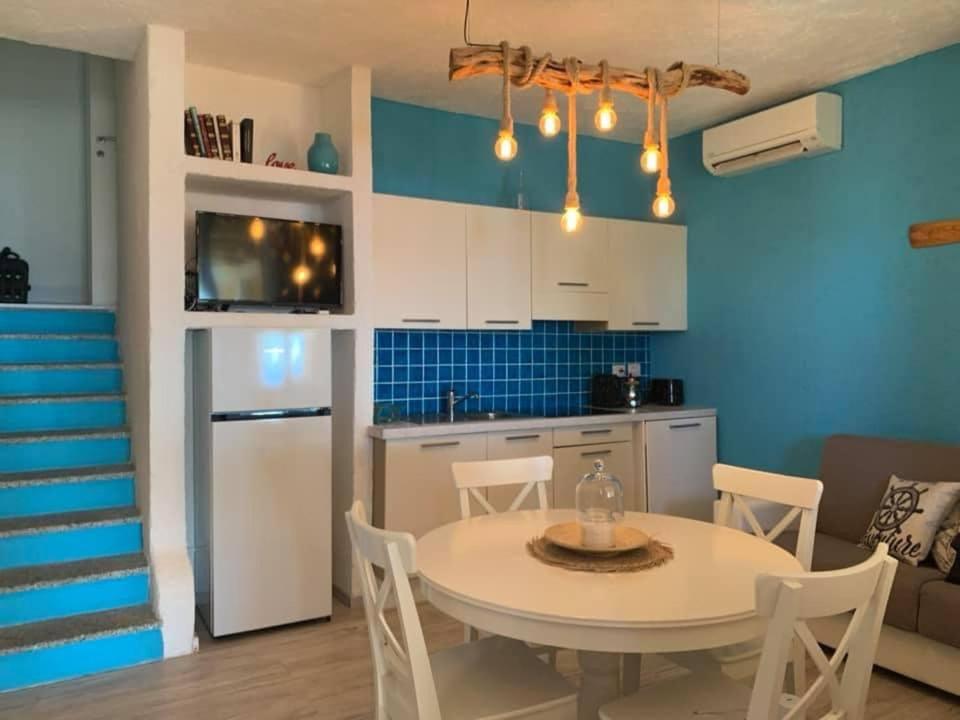 a kitchen and dining room with a white table and chairs at CASA TRIBOLATI SANTA REPARATA in Santa Reparata