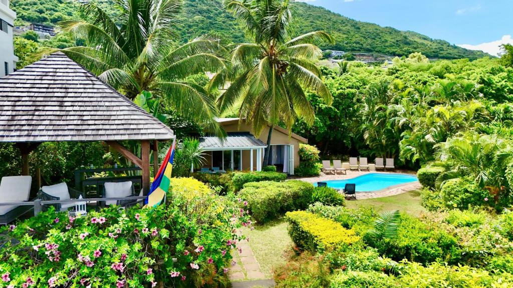 リヴィエール・ノワールにあるMaison 2 chambres avec vue et piscine privéeのヤシの木が植わるリゾートです。