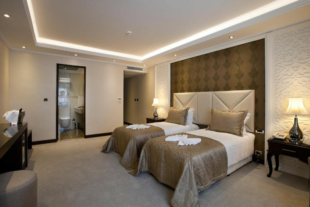 una camera d'albergo con due letti e un bagno di Just A Break - جست بريك لحجز الفنادق a Il Cairo