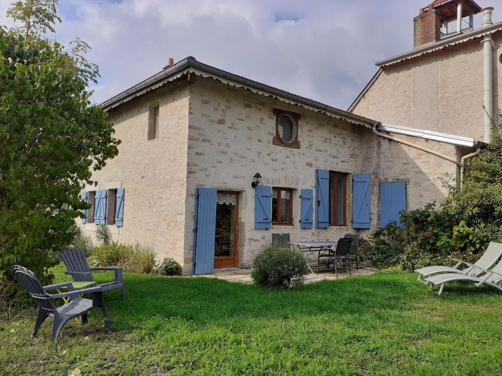 a building with chairs in the grass in front of it at Gîte familial calme avec jardin, wifi et équipements bébé, animaux acceptés - FR-1-584-92 in Saint-Germain