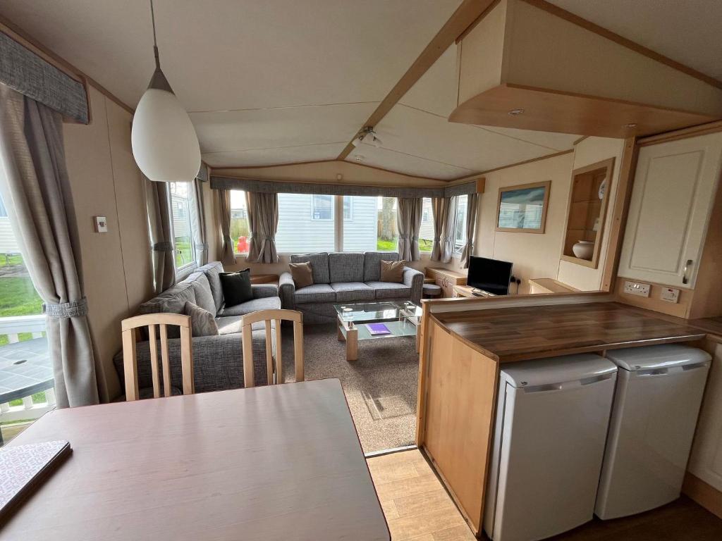 une cuisine et un salon d'une caravane dans l'établissement Bittern 8, Scratby - California Cliffs, Parkdean, sleeps 8, free Wi-Fi, bed linen and towels included, pet friendly - 2 minutes from the beach!, à Scratby