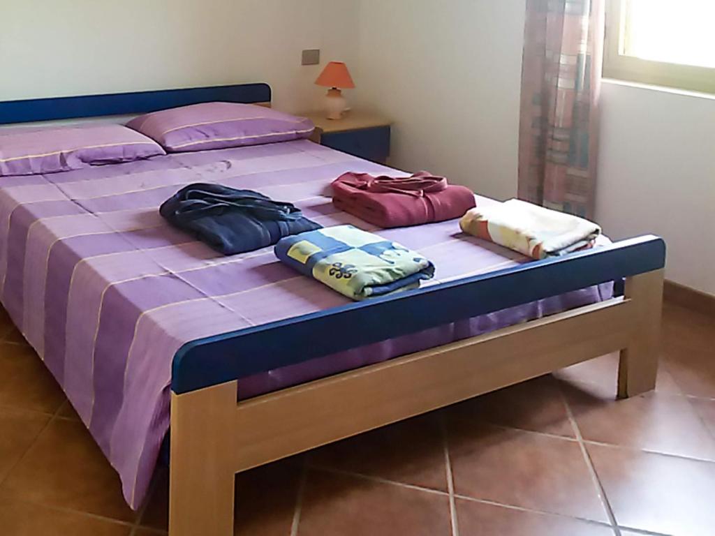 a bed with three bags sitting on top of it at Beach Apartments Poseidon in Casa dello Stumio