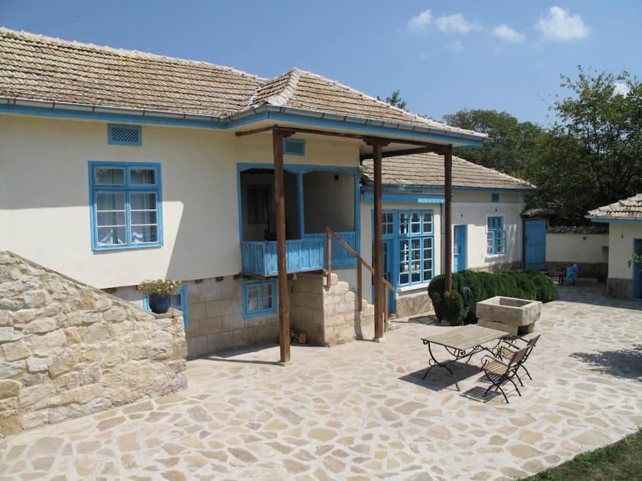 a house with a porch and a bench in front of it at Villa Rustica in Pomoshtitsa