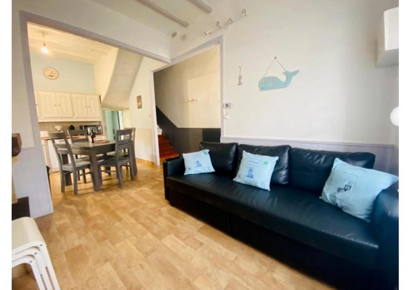 un salon avec un canapé noir et une table dans l'établissement Villa d'Octavie & de Garance, au Tréport