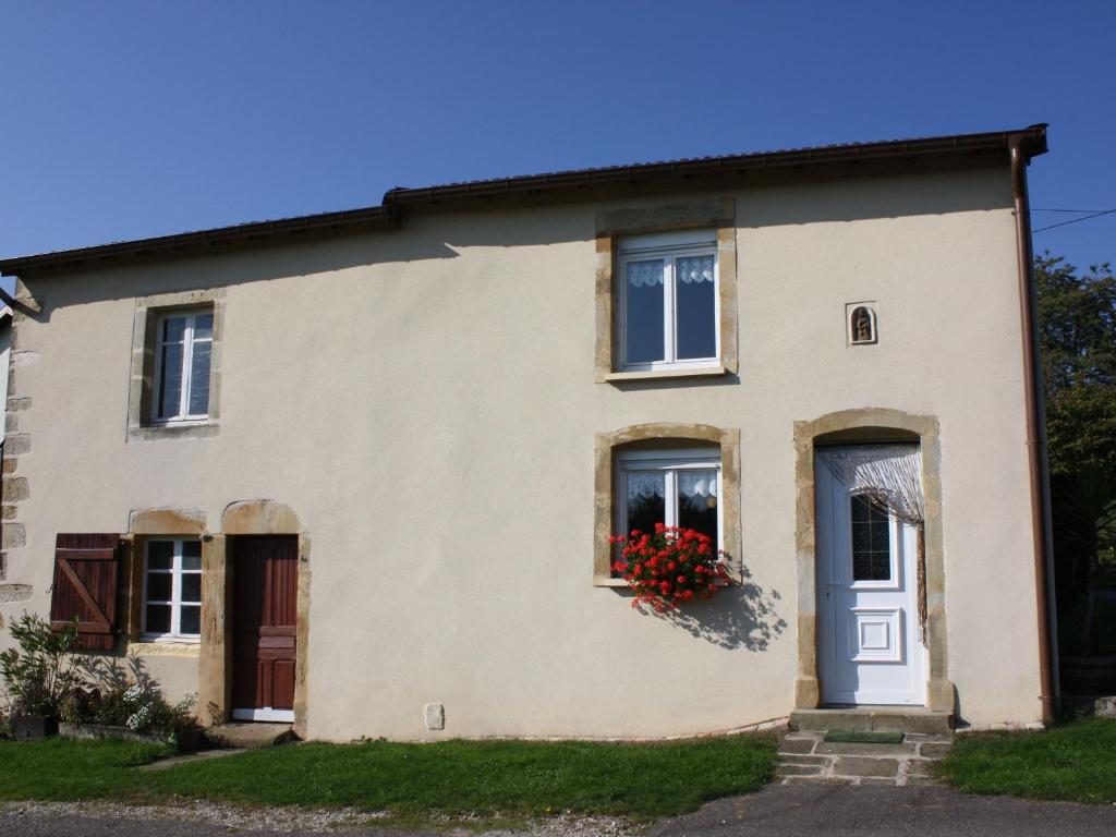 una casa con una puerta azul y flores en una ventana en Gîte Saint-Ouen-lès-Parey, 3 pièces, 4 personnes - FR-1-589-163, en Saint-Ouen-lès-Parey