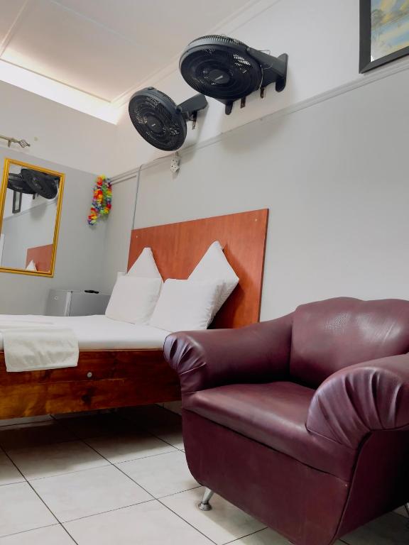 a bedroom with a bed and a couch and a mirror at Sunrise Guest Inn in Pretoria