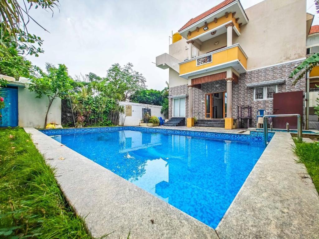 - une piscine en face d'une maison dans l'établissement Royal Experiences Buddha Sea View Villa, Mutukadu Beach ECR Chennai, à Chennai