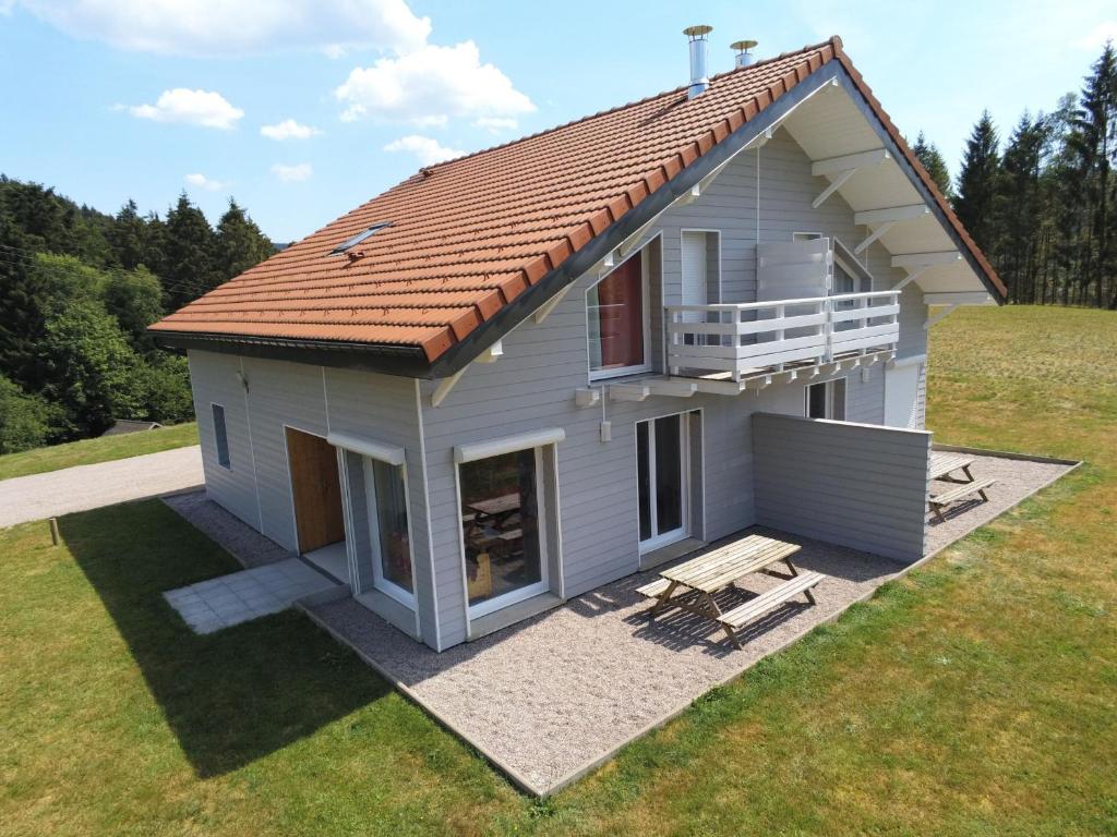 ein kleines weißes Haus mit einer Veranda und einer Terrasse in der Unterkunft Gîte Le Tholy, 4 pièces, 6 personnes - FR-1-589-217 in Le Tholy