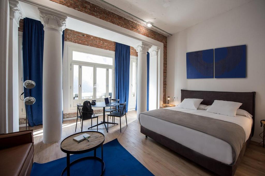 a bedroom with a bed and a table and a desk at room00 Gran Vía Hostel in Madrid