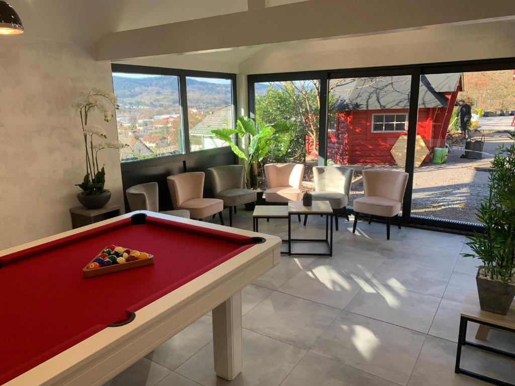 a pool table in a living room with a view at Évasion Vosgienne: Chalet de Luxe, Spa, Sauna, Proche Randos et Stations de Ski - FR-1-589-313 in Fresse-sur-Moselle