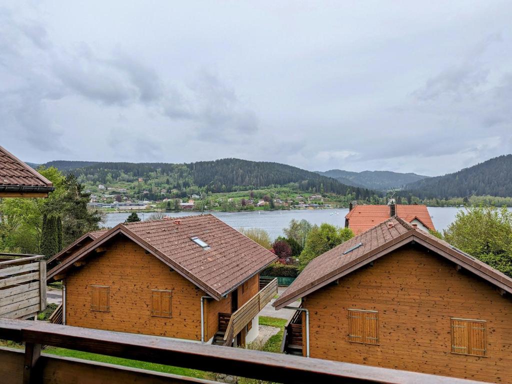 a group of buildings with a river in the background at Gîte Gérardmer, 2 pièces, 4 personnes - FR-1-589-305 in Gérardmer