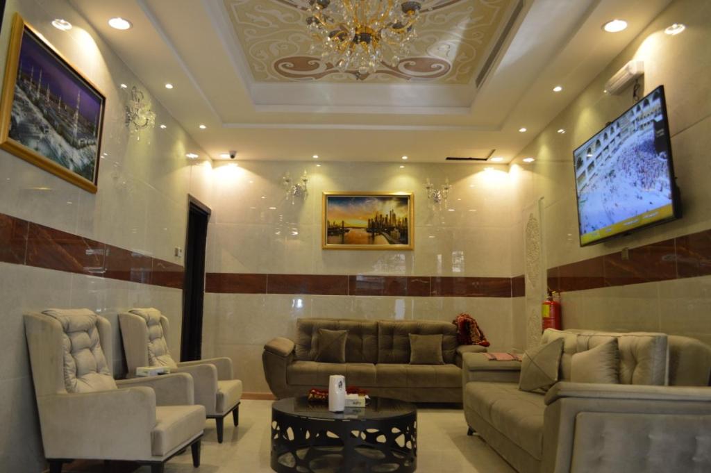 una gran sala de estar con sofás y TV. en العسيري هوتيل, en Taif