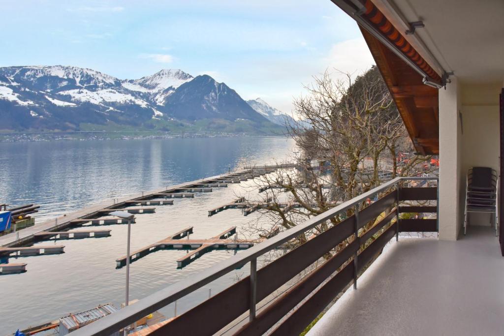 a view of a dock on a lake with mountains at Modern and charming apartment on the shores of Lake Lucerne in Gersau