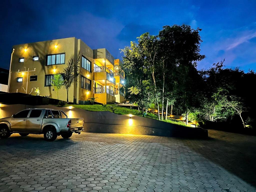 un camión estacionado frente a una casa por la noche en The KWASU Apartments, en Chipata