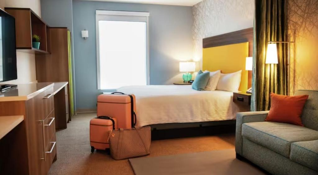 a hotel room with a bed and a couch at Home2 Suites By Hilton Ankeny in Ankeny