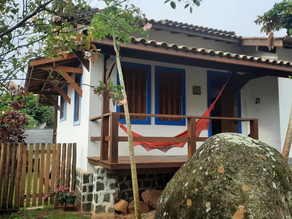 ein Haus mit einer Hängematte davor in der Unterkunft Casa aconchegante na Praia do Portinho in Ilhabela