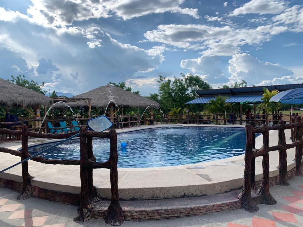 una piscina en un complejo con una valla alrededor en HOTEL CAMPESTRE LA ISLA, en Villavieja