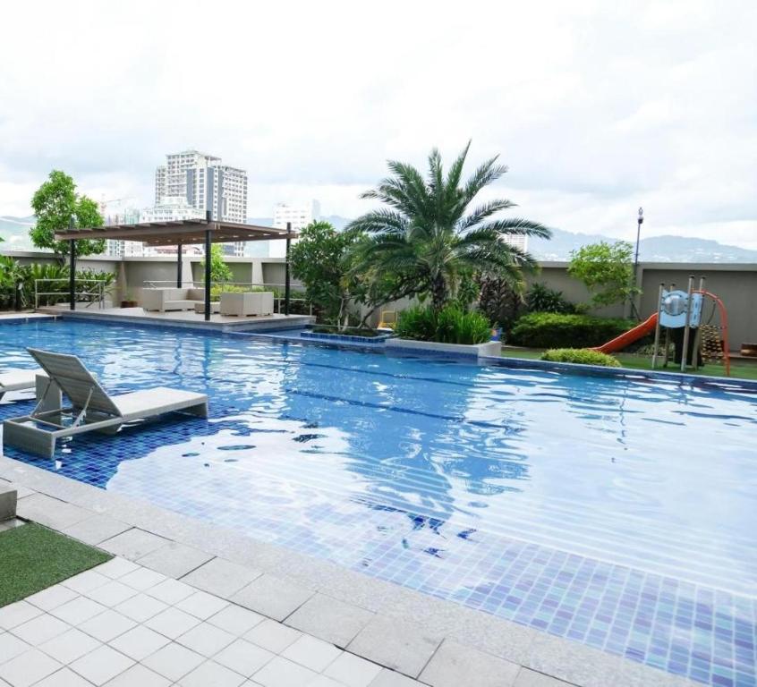- une grande piscine avec une chaise dans un bâtiment dans l'établissement Alex apartment Horizon 101, à Cebu