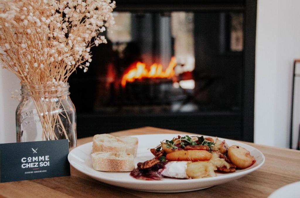 a plate of food on a table next to a fireplace at Suite 208 - Destination Mont-Orford in Magog-Orford