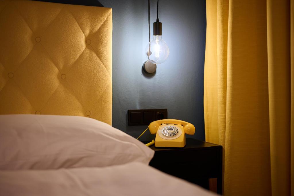 pokój z łóżkiem i żółtym telefonem na stole w obiekcie Boutique House happYellow Saalbach, inkl JokerCard w Saalbach Hinterglemm