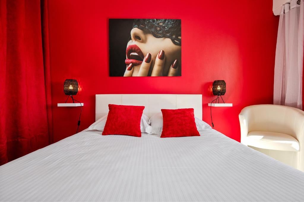 - une chambre rouge avec un lit blanc et des oreillers rouges dans l'établissement RED Port Nature, au Cap d'Agde