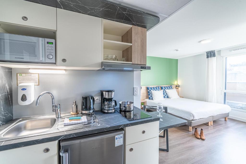 uma cozinha com um lavatório e uma cama num quarto em Break & Home Clermont-Ferrand Les Carmes Dechaux em Clermont-Ferrand