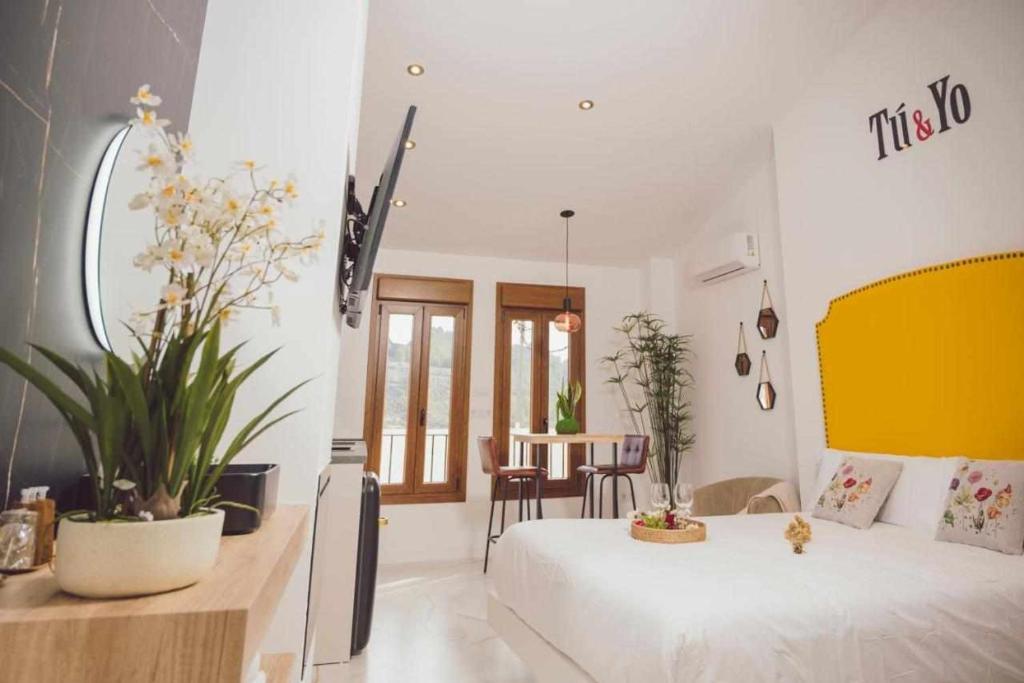 a bedroom with a white bed and a table and chairs at LOFT TÚ y YO in Alcalá del Júcar