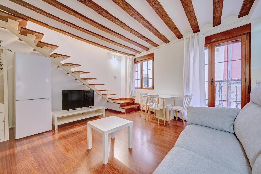ein Wohnzimmer mit einem Sofa und einer Treppe in der Unterkunft Dúplex Portales By Clabao in Logroño