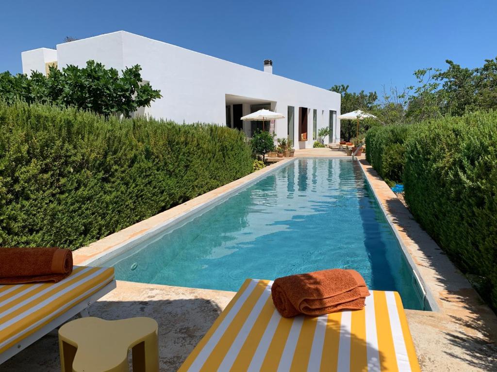 einen Pool mit zwei Stühlen und ein Haus in der Unterkunft Casa Norah Puglia in Serranova