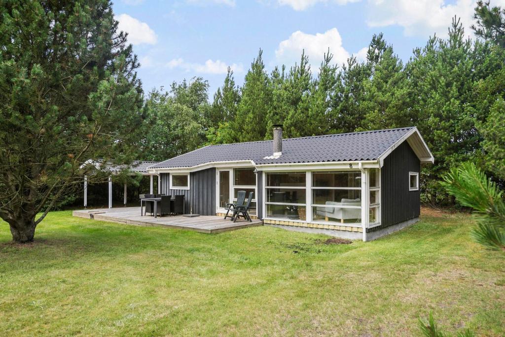 een klein huis met een terras en een patio bij Little Fiskerbanke - Lovely, Private, And Family-friendly Holiday Home in Saltum