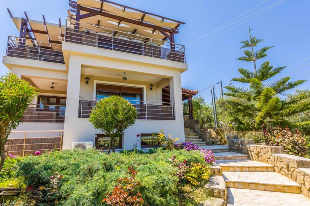 a house with a balcony and some plants at Oliva Blu in Zakynthos Town