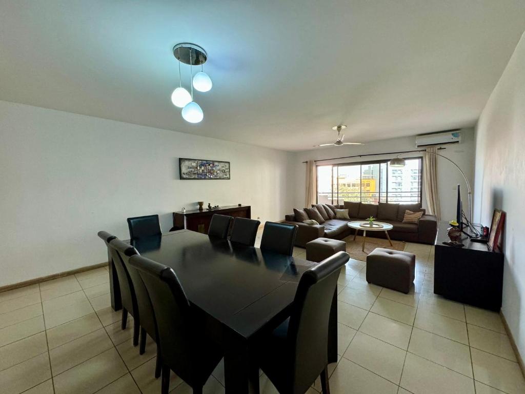 een eetkamer en een woonkamer met een tafel en stoelen bij Mansa home in Dakar